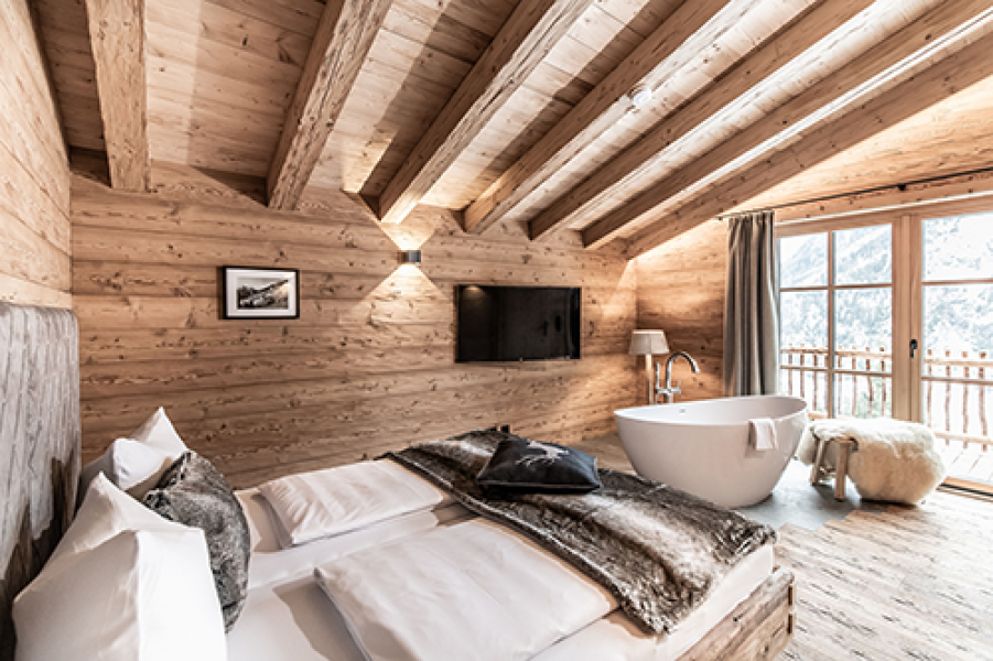 schlafzimmer mit freistehender wohlfuehlwanne und balkon c ratko photography benglerwald berg chaletdorf 0